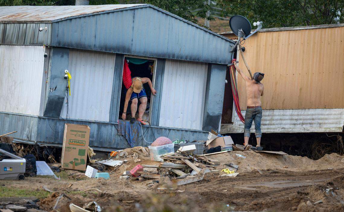 Brooke Canning climbs out a window of her damaged home on Wednesday, October 2, 2024 in Old Fort, N.C. Canning was trying to salvage personal items after flood waters from Hurricane Helene flooded Mill Creek and her neighborhood in the center of town.