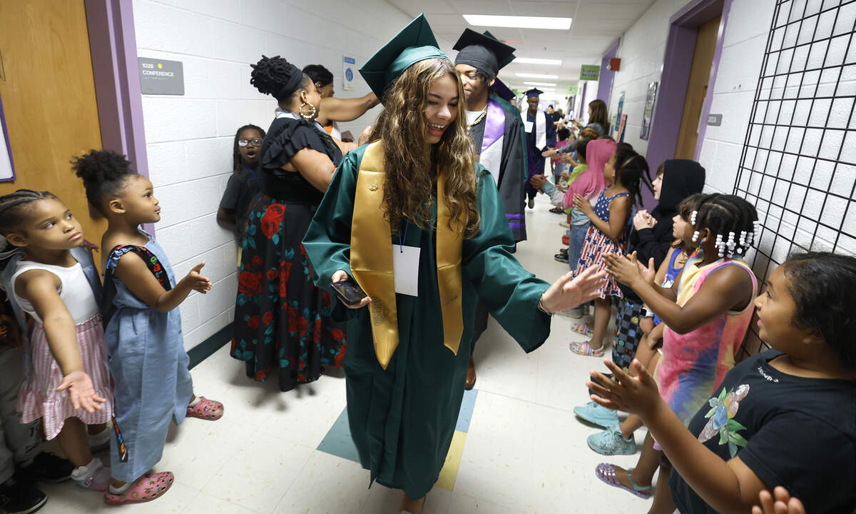 Enloe High School senior Zoey Meza is celebrated while walking the halls of Powell Elementary in Raleigh on Wednesday. Meza and other high school graduates who are alumni of Powell Elementary returned to the school for the celebration.