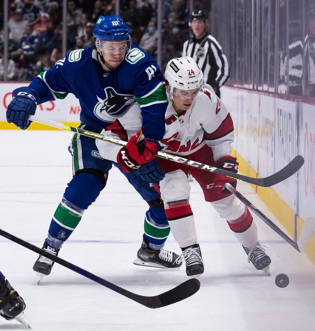 Vancouver Canucks’ Juho Lammikko, left, of Finland, and Carolina Hurricanes’ Seth Jarvis vie for the puck during the second period of an NHL hockey game in Vancouver, British Columbia, Sunday, Dec. 12, 2021. (Darryl Dyck/The Canadian Press via AP)