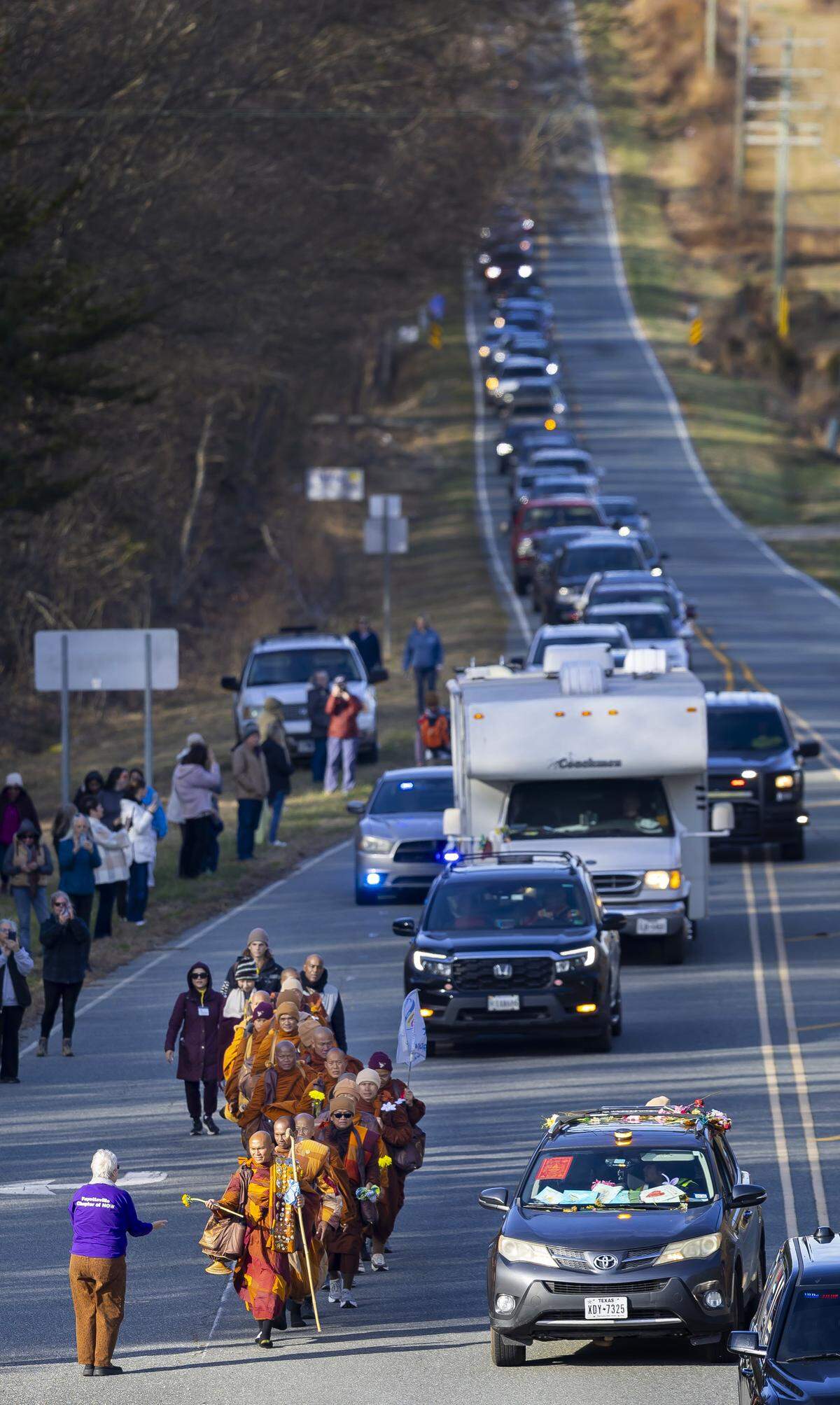 Buddhist Monks pass spectators as they take S. Greensboro Street  to US 421 during the Walk for Peace on Wednesday, January 21, 2026 in Liberty, N.C.