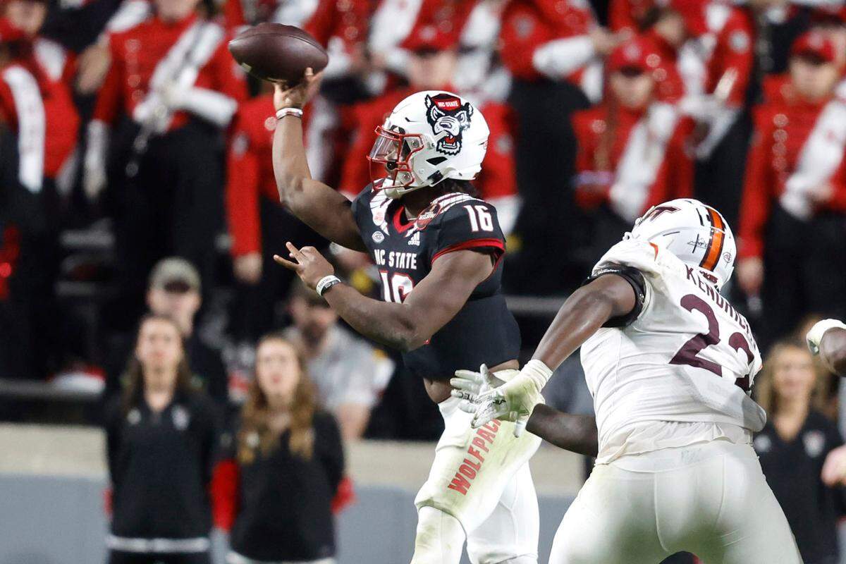 N.C. State quarterback MJ Morris (16) throws as Virginia Tech defensive lineman Mario Kendricks (22) pressures him during the second half of N.C. State’s 22-21 victory over Virginia Tech at Carter-Finley Stadium in Raleigh, N.C., Thursday, Oct. 27, 2022.