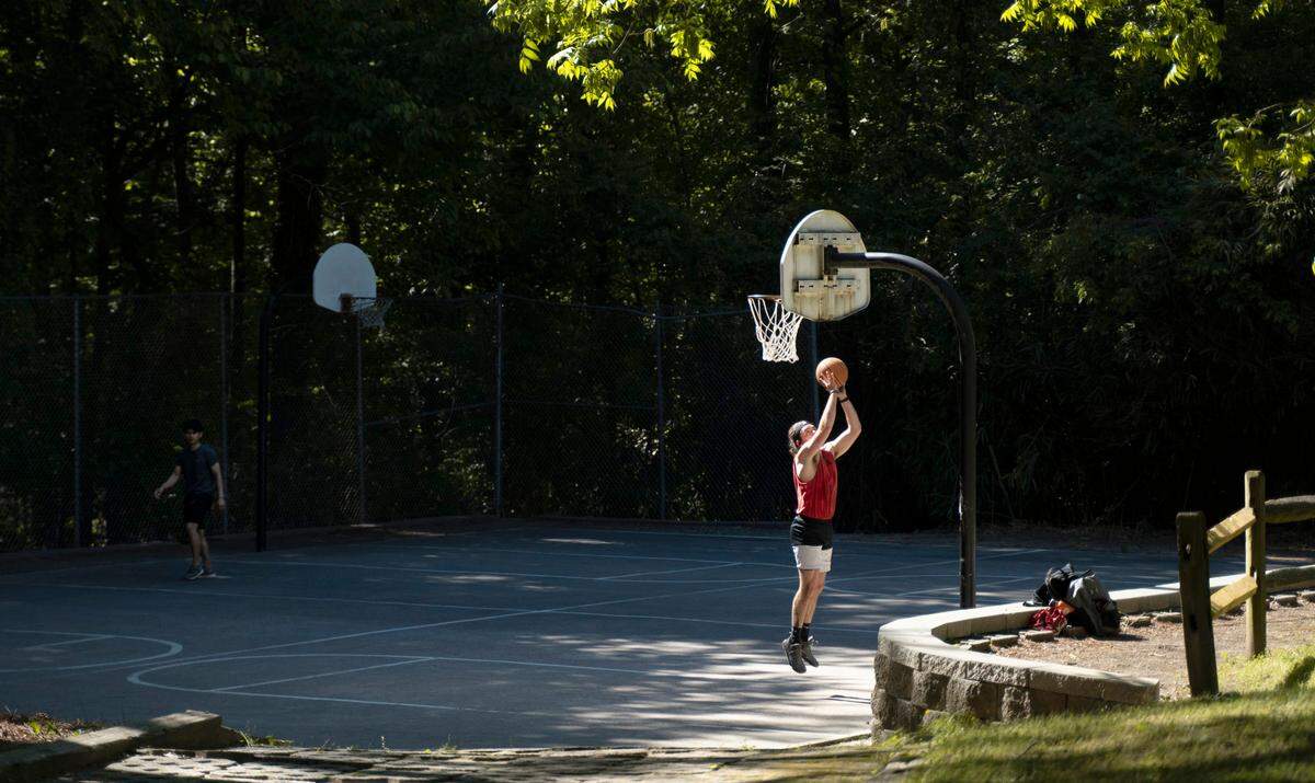 People play basketball at the hoops outside the Sertoma Art Center in Raleigh, N.C., on Tuesday, May 10, 2022.