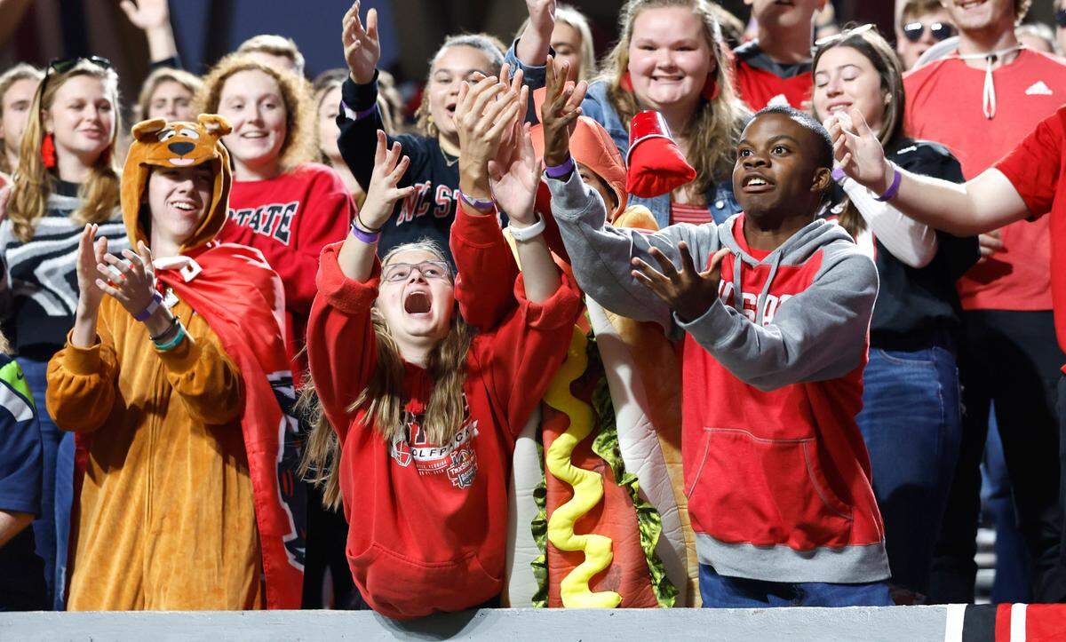 Wolfpack fans try to catch a t-shirt thrown by head coach Dave Doeren before N.C. State’s game against Virginia Tech at Carter-Finley Stadium in Raleigh, N.C., Thursday, Oct. 27, 2022.