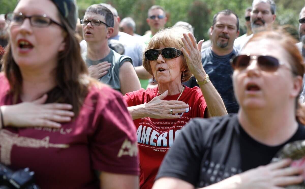 Beverly Lung of Walkerton, N.C. center, sings the national anthem during the National Second Amendment Rally at Halifax Rally Saturday, April 14, 2018.