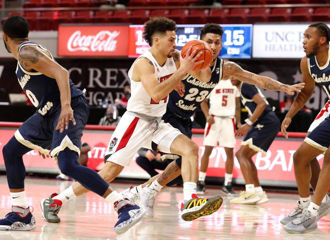 N.C. State’s Devon Daniels (24) drives past Charleston Southern’s Sean Price (23) during N.C. State’s game against Charleston Southern in the Wolfpack Invitational at Reynolds Coliseum in Raleigh, N.C., Wednesday, Nov. 25, 2020.