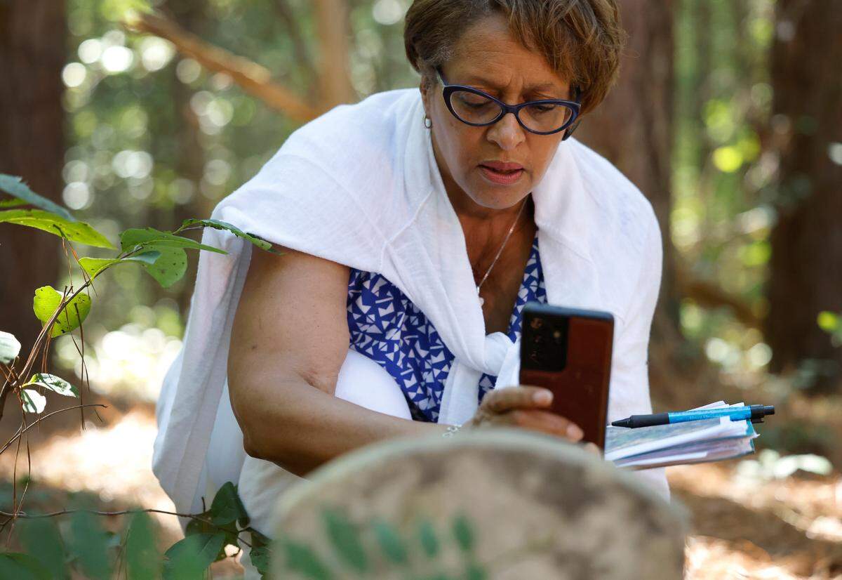 Valerie Frasier takes a photo of a gravestone while visiting Byrd Chapel Cemetery off New Elam Church Rd. in Moncure, N.C., on Friday, Sept. 15, 2023.
