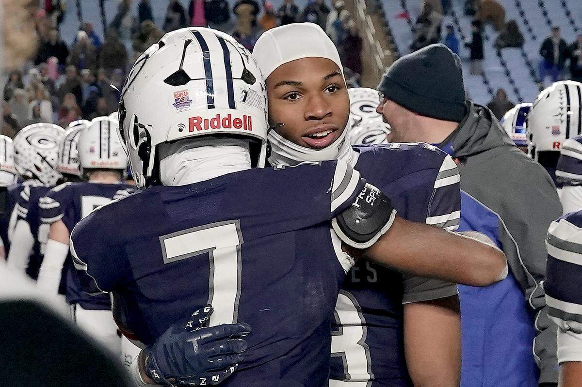 Grimsley cornerback Patrick Carter (7) embraces wide receiver Kosci Barnes (3) after their victory over Clayton in the NCHSAA 7A Football Championship.  The Clayton Comets and the Grimsley Whirlies met in the NCHSAA 7A football Championships in Chapel Hill, NC on December 12, 2025.