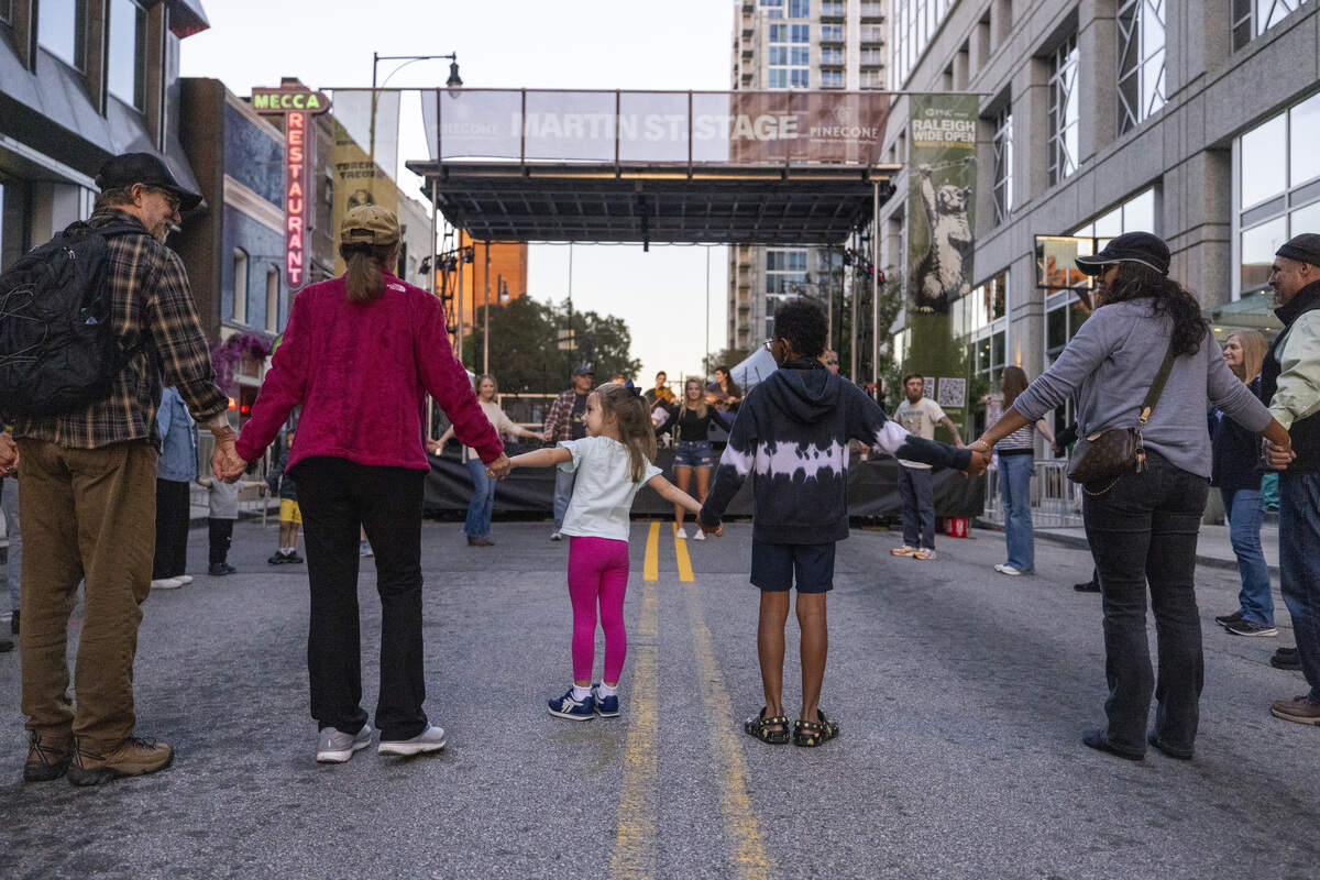 Festival-goers square dance on Martin Street during the Raleigh Wide Open music festival in downtown Raleigh on Friday, Oct. 3, 2025. The event features live bluegrass, folk, Americana and gospel artists.