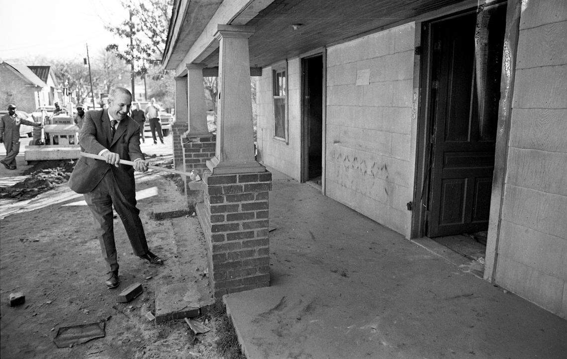 Raleigh Mayor Seby Jones takes sledgehammer to the first house demolished in Fourth Ward urban renewal project on Feb. 19, 1971.