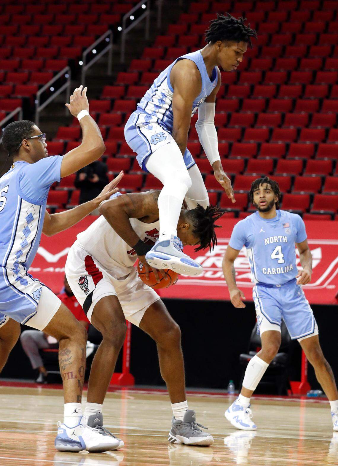 North Carolina’s Caleb Love (2) hurdles over N.C. State’s Manny Bates (15) during the second half of N.C. State’s 79-76 victory over UNC at PNC Arena in Raleigh, N.C., Tuesday, December 22, 2020.