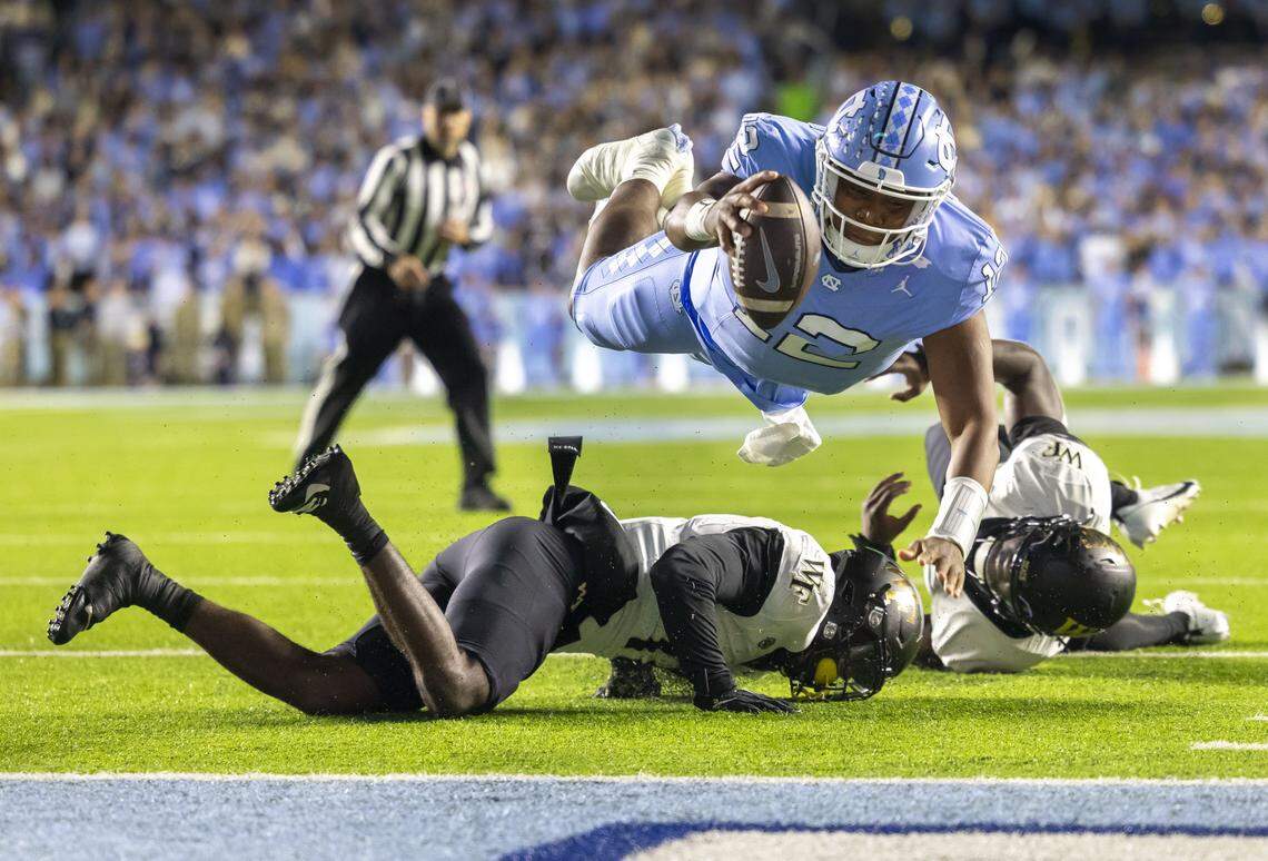 North Carolina quarterback Jacolby Criswell (12) dives over Wake Forest defensive back Zamari Stevenson (17) to score on a 4-yard run to give the Tar Heels a 7-3 lead in the second quarter on Saturday, November 16, 2024 at Kenan Stadium in Chapel Hill, N.C.