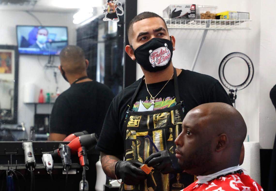 Eder Jamil, barber at The Right Cut Barber Shop in Cary, N.C., watches as the verdict is read in the trial of Derek Chauvin Tuesday, April 20, 2021. “It was something that we were all waiting for” said Jamil. “The verdict that we all knew he deserved.” With Jamil is customer Chris Perkins.