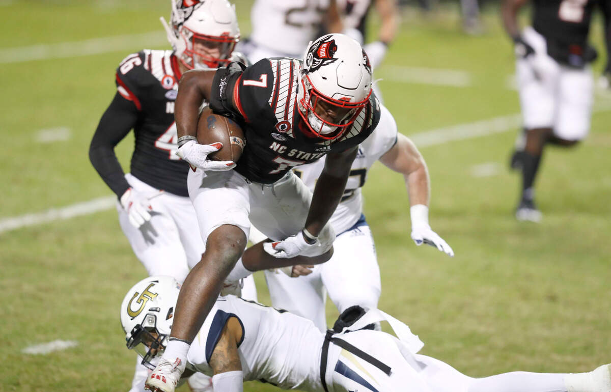 N.C. State running back Zonovan ‘Bam’ Knight (7) tries to hurdle over Georgia Tech defensive back Tobias Oliver (8) on a kickoff return during the second half of N.C. State’s 23-13 victory over Georgia Tech at Carter-Finley Stadium in Raleigh, N.C., Saturday, Dec. 5, 2020.