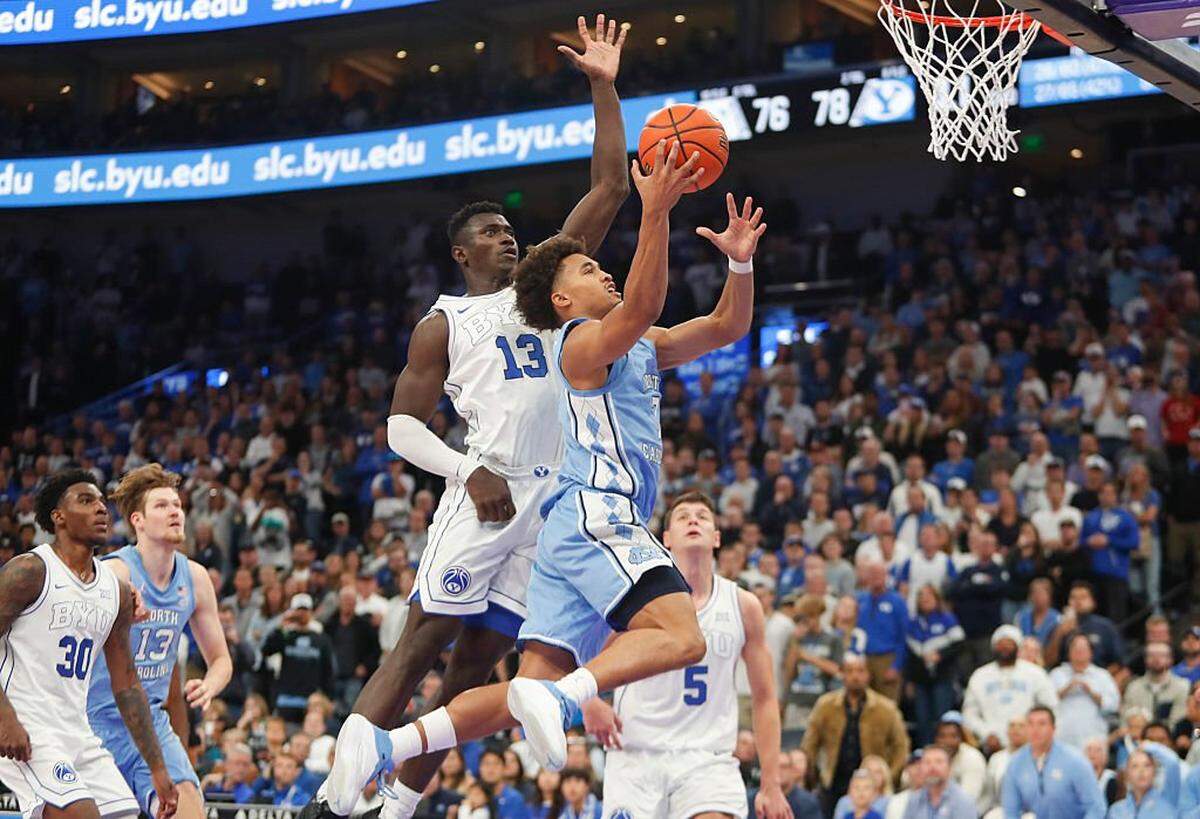 Seth Trimble (7) of the North Carolina Tar Heels is pressured by Keba Keita (13) of the Brigham Young Cougars as he drives to the basket during the second half of their exhibition game at the Delta Center on October 24, 2025 in Salt Lake City, Utah.