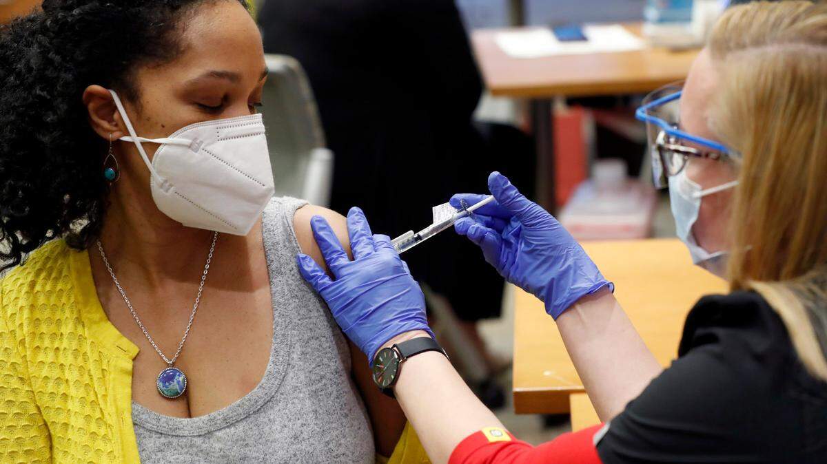 UNC Rex Hospital’s Dr. Marie Ambroise Thigpen, left, gets her second COVID-19 vaccine shot, administered by Amy Donnelly, at UNC Rex Hospital in Raleigh, N.C., Thursday, January 7, 2021.