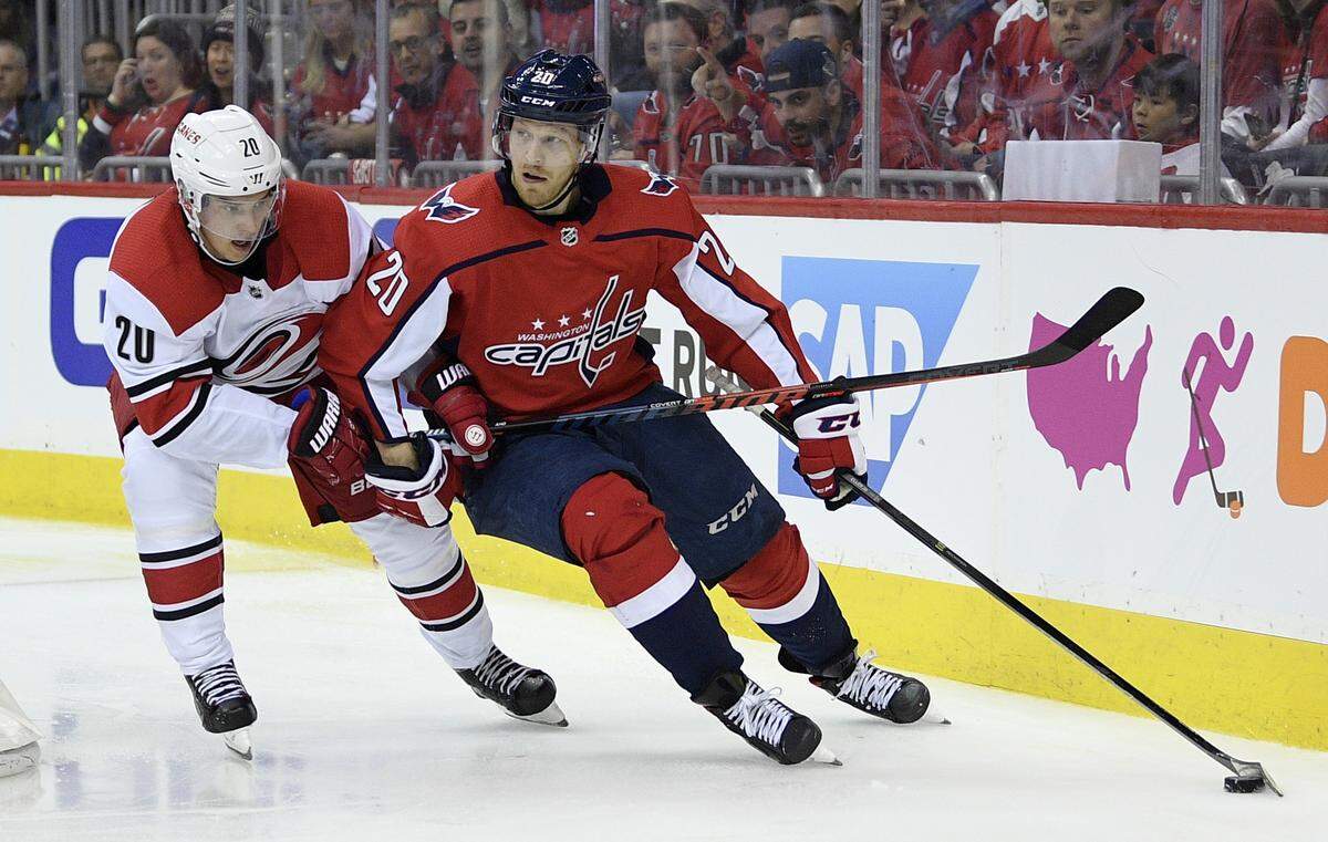 Washington Capitals center Lars Eller, right, of Denmark, skates with the puck against Carolina Hurricanes center Sebastian Aho, left, of Finland, during the second period of Game 1 of an NHL hockey first-round playoff series, Thursday, April 11, 2019, in Washington.