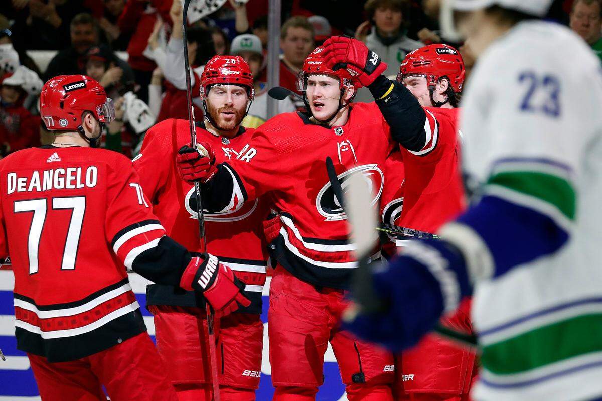 Carolina Hurricanes’ Martin Necas (88) celebrates his goal with teammates Tony DeAngelo (77), Ian Cole (28) and Andrei Svechnikov, right, during the second period of an NHL hockey game against the Vancouver Canucks in Raleigh, N.C., Saturday, Jan. 15, 2022. (AP Photo/Karl B DeBlaker)