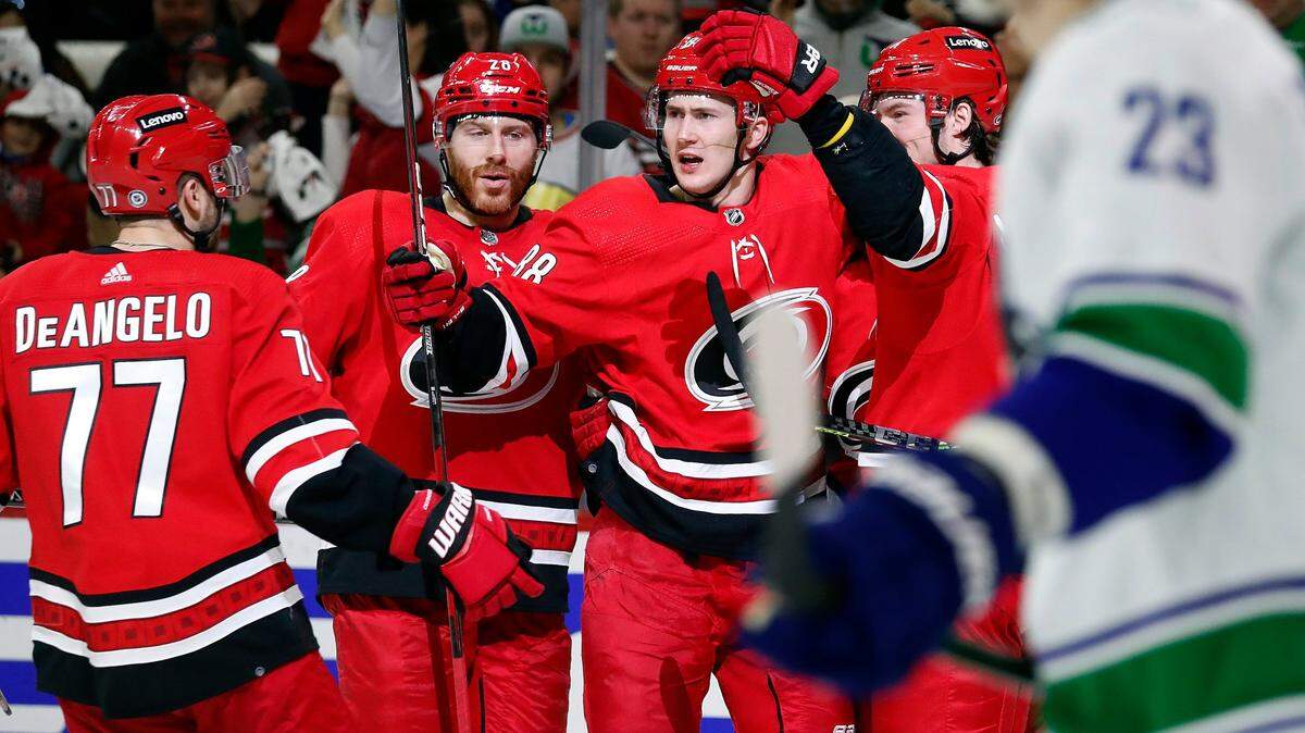 Carolina Hurricanes’ Martin Necas (88) celebrates his goal with teammates Tony DeAngelo (77), Ian Cole (28) and Andrei Svechnikov, right, during the second period of an NHL hockey game against the Vancouver Canucks in Raleigh, N.C., Saturday, Jan. 15, 2022. (AP Photo/Karl B DeBlaker)