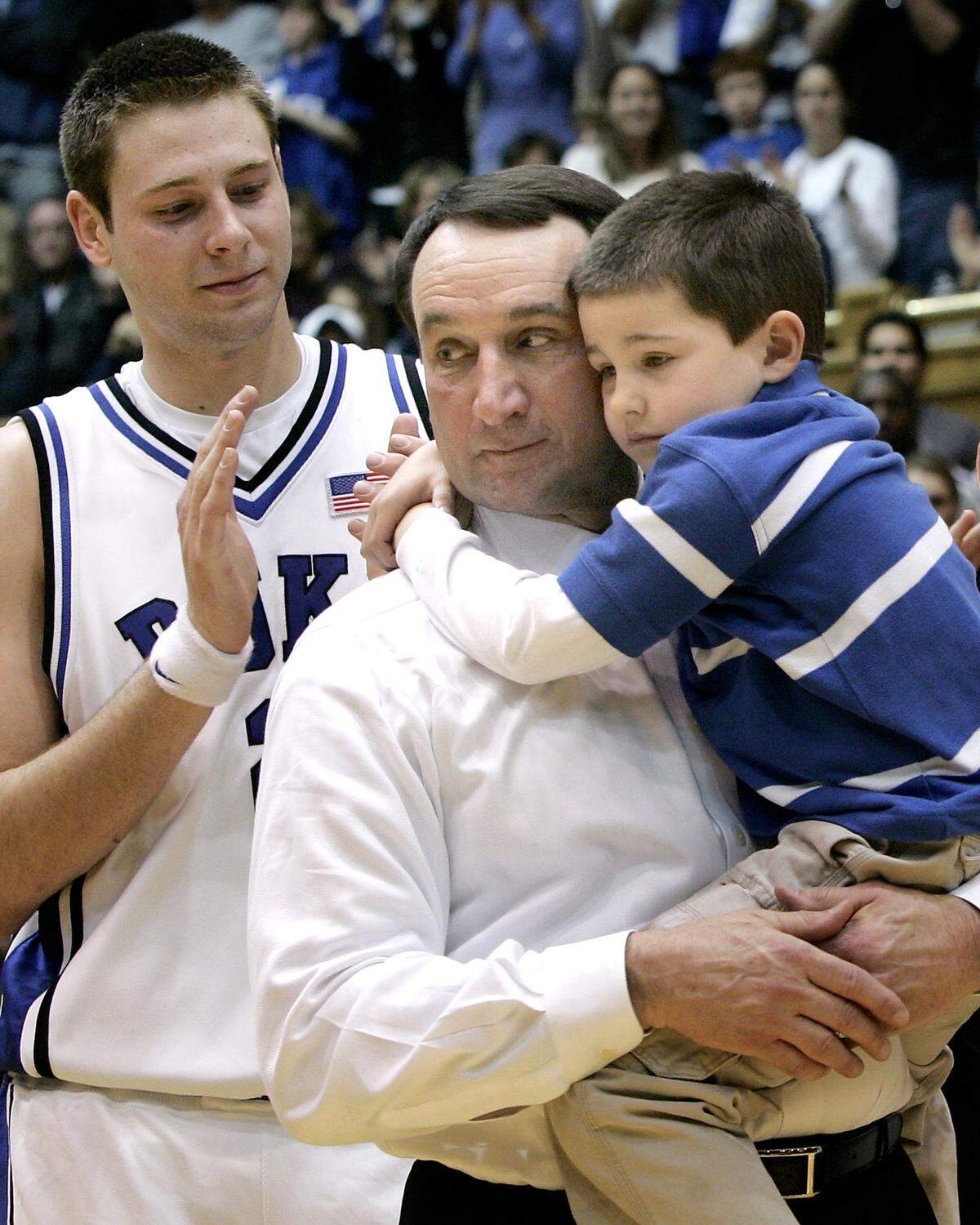 Duke coach Mike Krzyzewski holds his grandson Michael Savarino while standing near team co-captain Josh McRoberts as Krzyzewski is recognized for his 700th win following Duke’s victory over Georgia Tech at Cameron Indoor Stadium on Sunday, Feb. 18, 2007.
