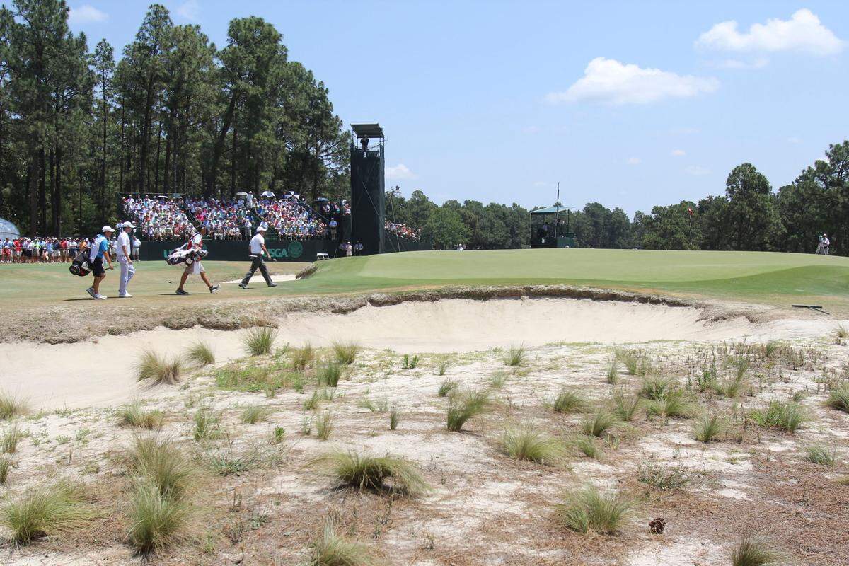 Webb Simpson (second from left) and Phil Mickelson (far right) walk to the 3rd green during the third round of the 2014 U.S. Open golf tournament at Pinehurst Resort Country Club.