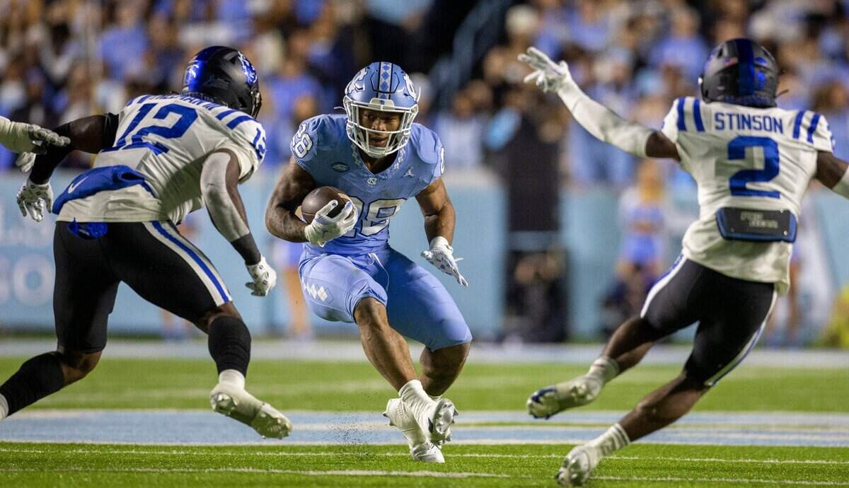 North Carolina running back Omarion Hampton (28) carries the ball for 11 yards as he looks for running room against Duke’s Tre Freeman and (12) Jaylen Stinson (2) in the first quarter on Saturday, Nov. 11, 2023 at Kenan Stadium in Chapel Hill, N.C.