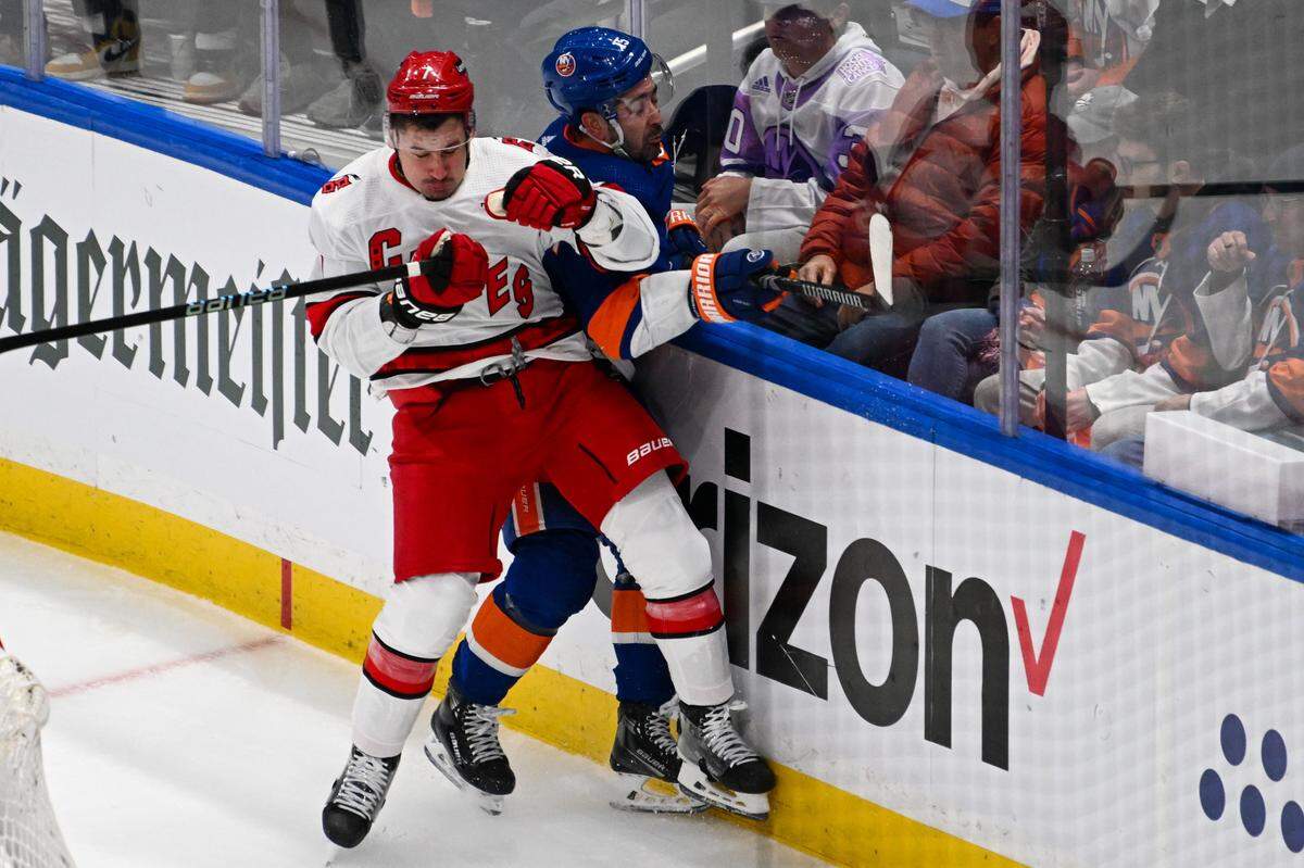 Apr 25, 2024; Elmont, New York, USA; Carolina Hurricanes defenseman Dmitry Orlov (7) checks New York Islanders right wing Cal Clutterbuck (15) during the first period in game three of the first round of the 2024 Stanley Cup Playoffs at UBS Arena. Mandatory Credit: Dennis Schneidler-USA TODAY Sports