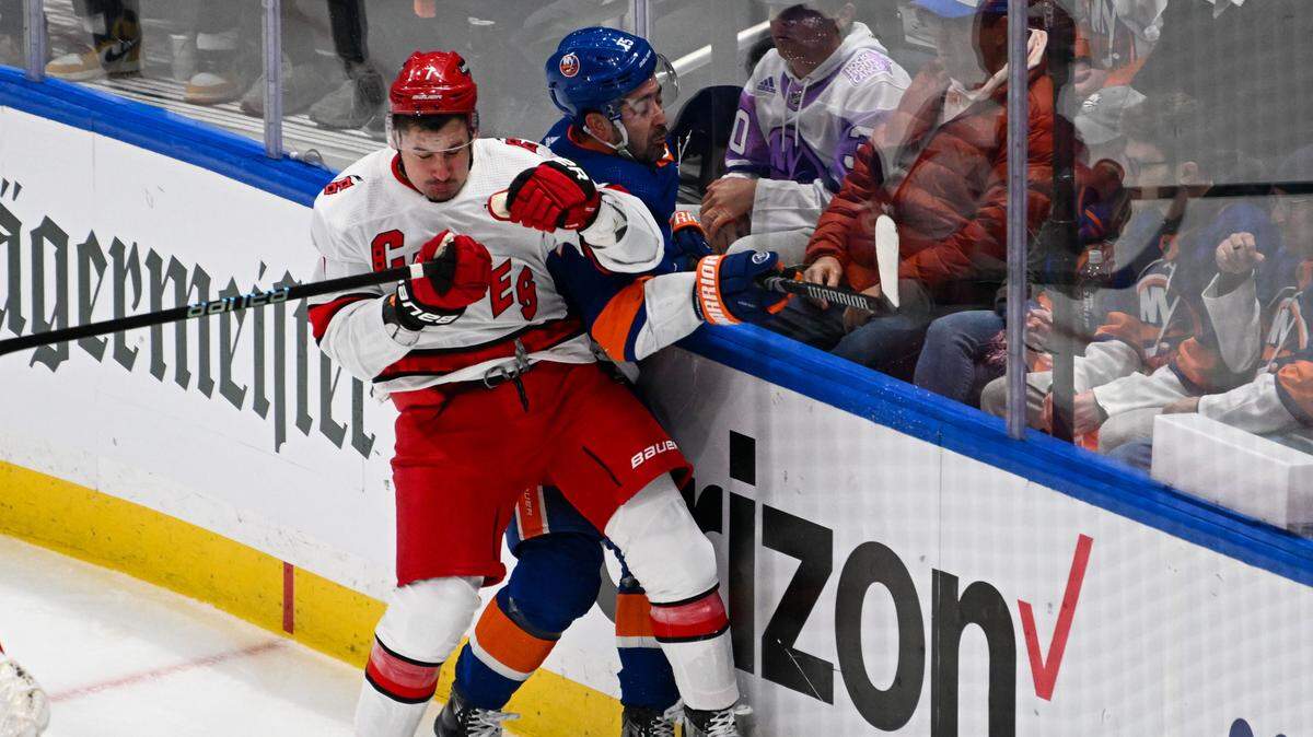 Carolina Hurricanes defenseman Dmitry Orlov (7) checks New York Islanders right wing Cal Clutterbuck (15) during the first period in game three of the first round of the 2024 Stanley Cup Playoffs at UBS Arena.