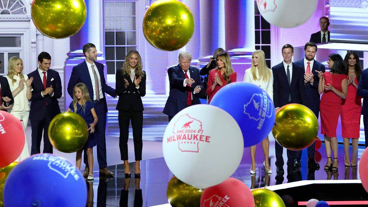 Donald Trump and his family, along with JD Vance and his wife Usha Chilukuri Vance, stand on stage as balloons drop at the the final day of the Republican National Convention at the Fiserv Forum on July 18, 2024.