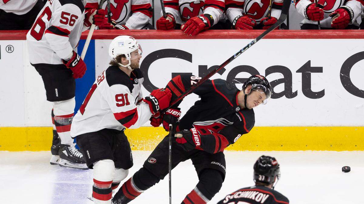 Carolina Hurricanes center Jesperi Kotkaniemi (82) reacts after taking a stick to his face from New Jersey Devils center Dawson Mercer (91) in the second overtime, to set up the game winning power play goal by Sebastian Aho on Tuesday, April 29, 2025 at Lenovo Center in Raleigh, N.C.