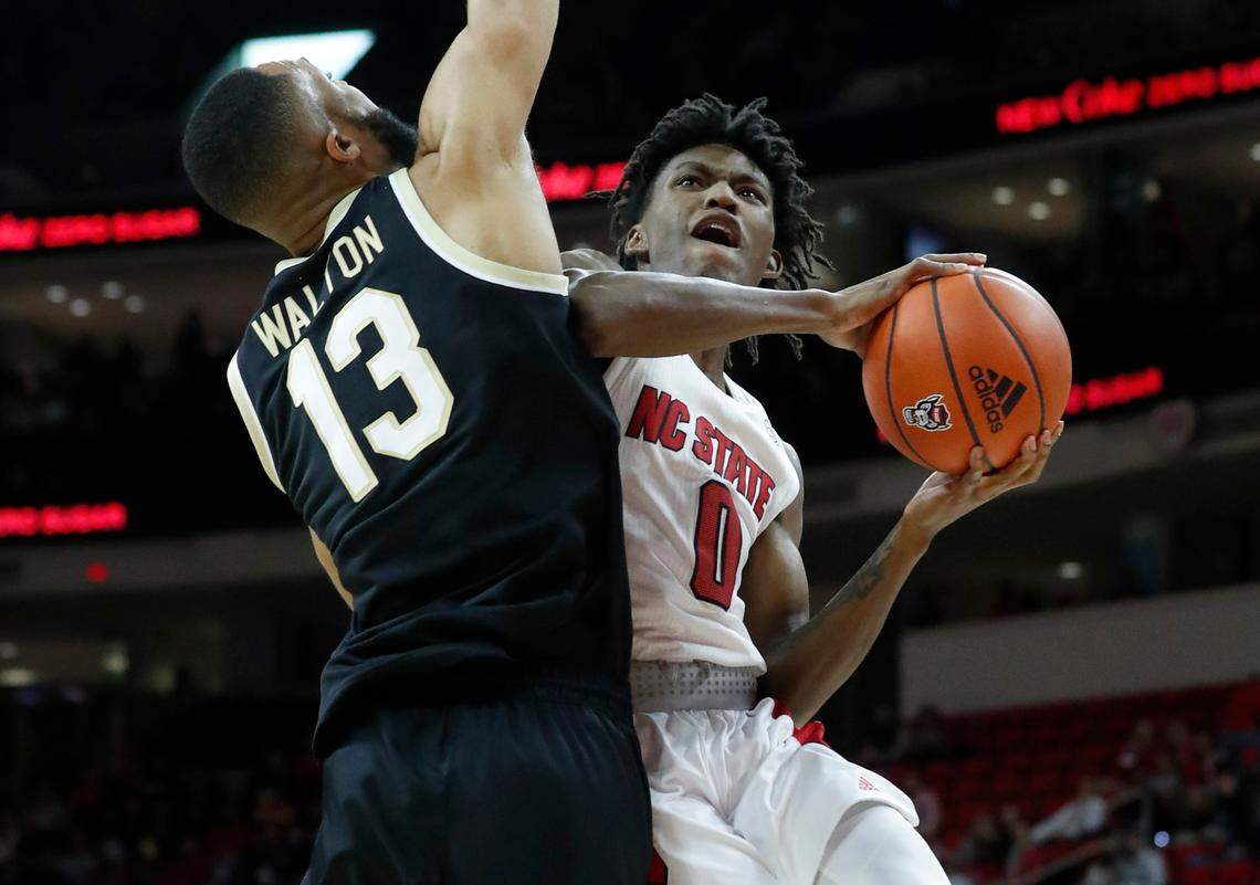 N.C. State’s Terquavion Smith (0) drives to the basket as Wake Forest’s Dallas Walton (13) defends during the first half of N.C. State’s game against Wake Forest at PNC Arena in Raleigh, N.C., Wednesday, Feb. 9, 2022.