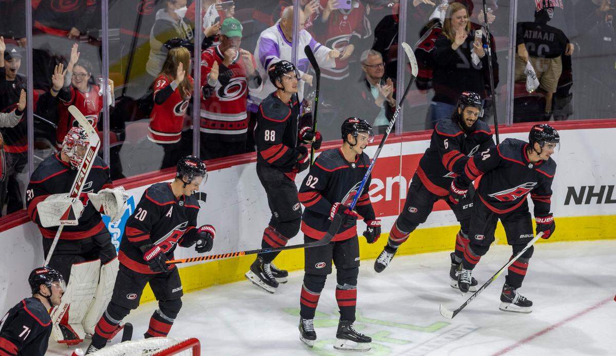 The Carolina Hurricanes Jesperi Kotkaniemi (82) and his teammate crash the boards as they celebrate their 5-3 victory over Ottawa on Wednesday, October 11, 2023 at PNC Arena, in Raleigh N.C.