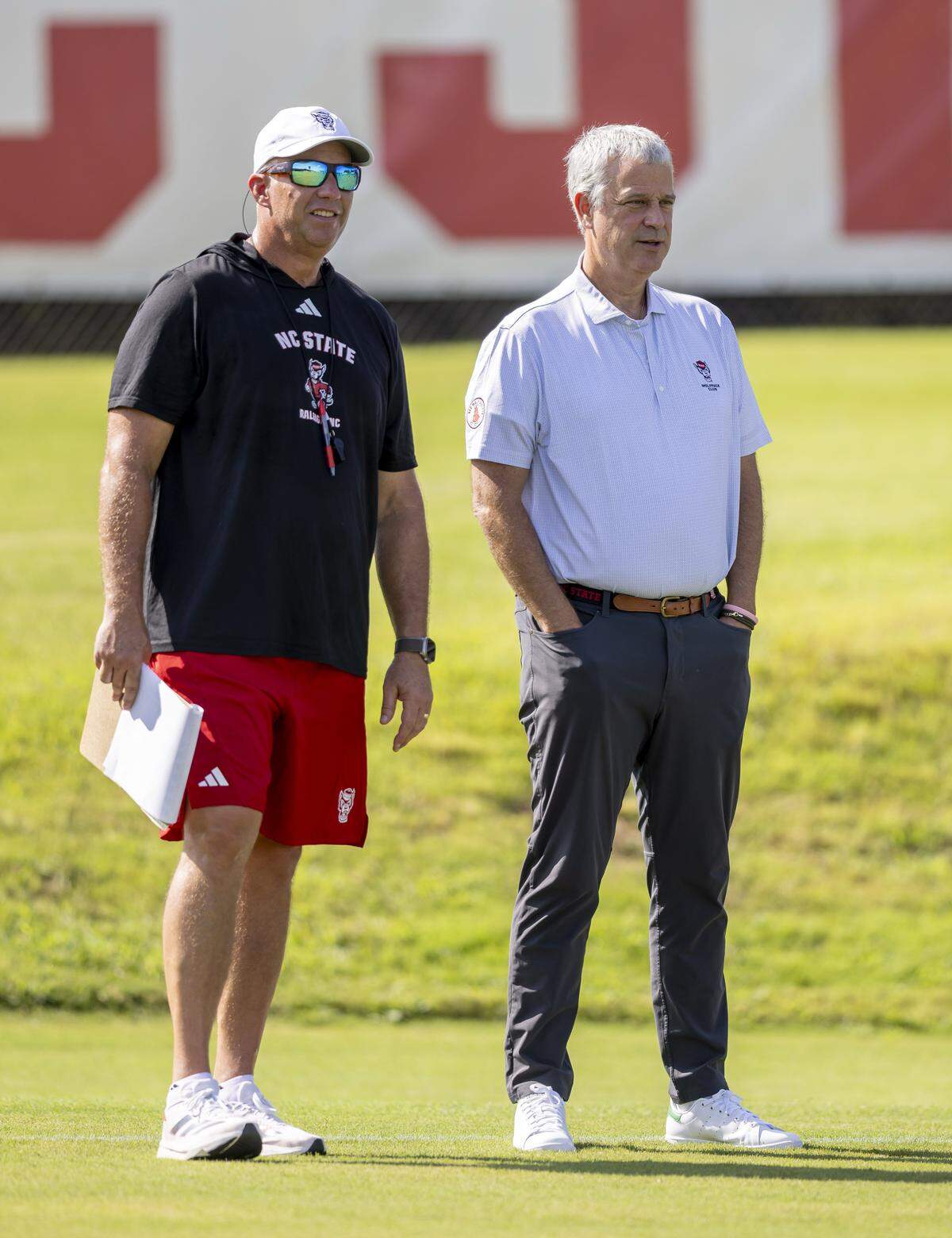 N.C. State head coach Dave Doeren talks with athletic director Boo Corrigan as they watch the Wolfpack football practice on Tuesday, July 30, 2025 in Raleigh, N.C.