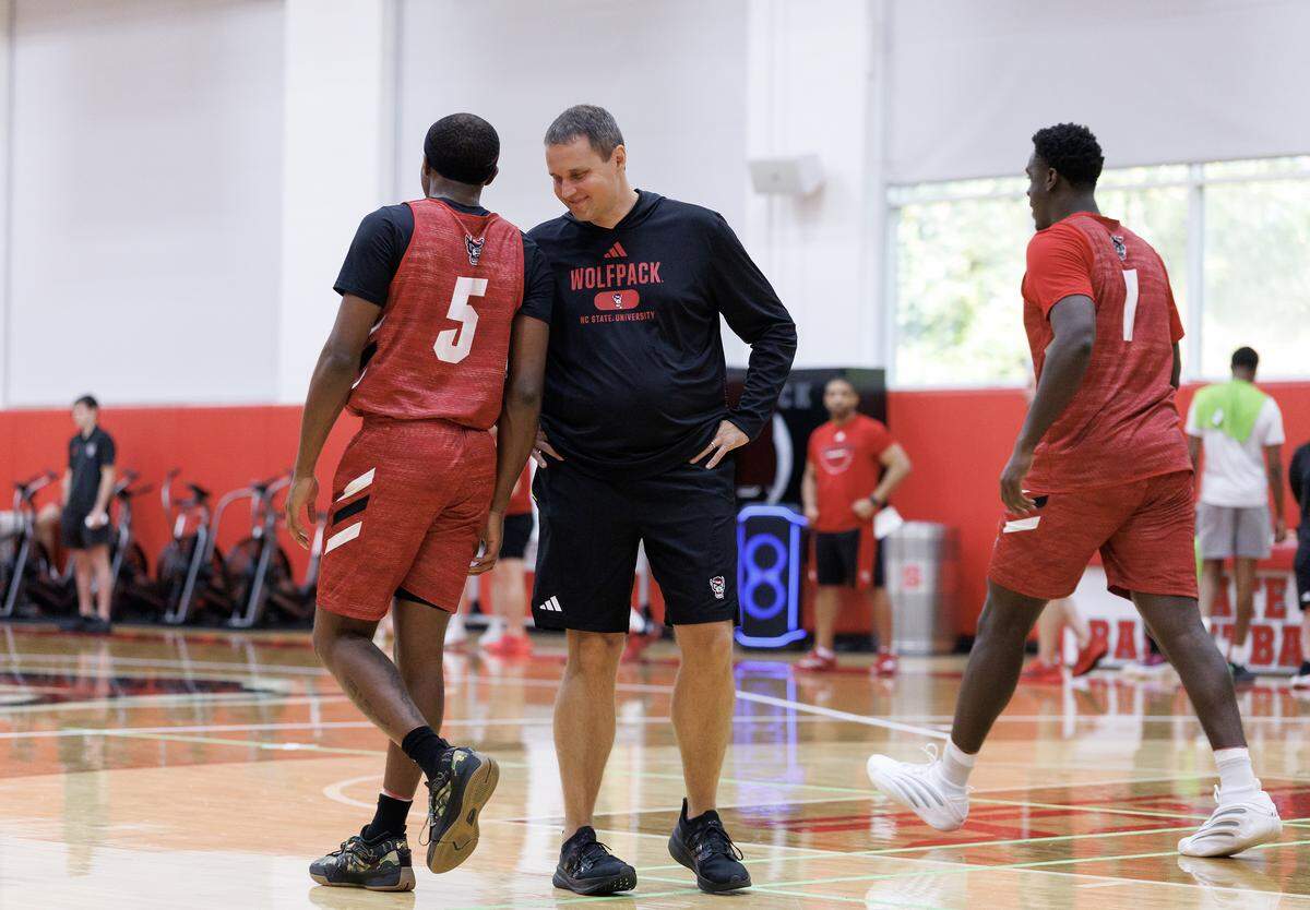 N.C. State head coach Will Wade speaks with Tre Holloman at the start of the team’s first official practice on Monday, Sept. 22, 2025, in Raleigh, N.C. at Dail Basketball Center. 