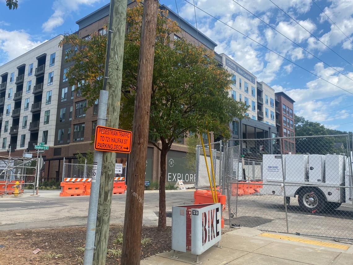 A sign directs pedestrians to a parking deck while construction continues through Seaboard Station. Small businesses there say it is not enough to keep customers coming.