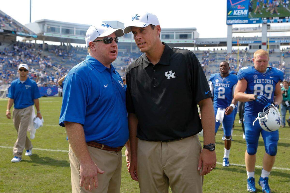 Kentucky head coach Mark Stoops, left, talks with defensive coordinator D.J. Eliot after UK defeated Miami (Ohio) 41-7 in 2013.