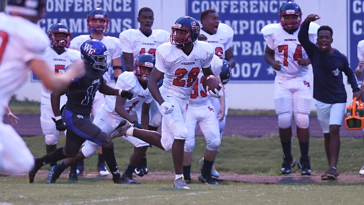 Zonovan Knight (28) of Southern Nash escapes the pursuit of Nasir Mills (14) of Wake Forest to score a 80-yard run touchdown. The Southern Nash Firebirds visited the Wake Forest Cougars in a high school football game on September 27, 2018.