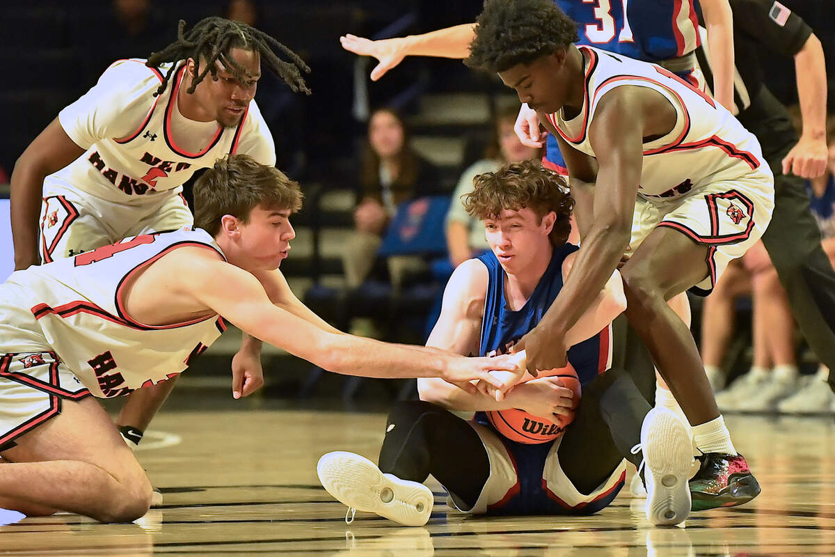 Sanderson’s Nathan Fife (5) protects the ball from new Hanover’s Nolan Billings (34) and Jazir Wright-Mcghee (14) during the first half. The Sanderson Spartans and the New Hanover Wildcats met in the NCHSAA 4A East Regional Final in Winston-Salem, N.C. on March 12, 2025.
