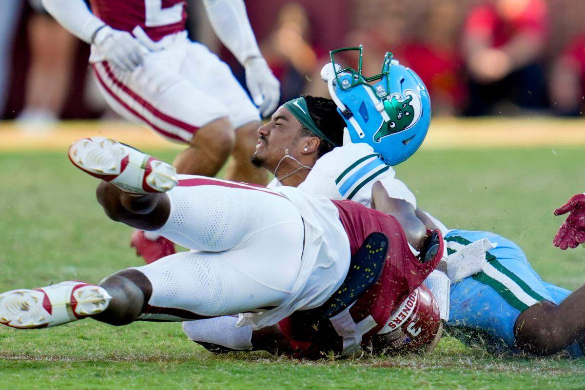 Tulane Green Wave quarterback Darian Mensah (10) loses his helmet as Oklahoma Sooners defensive back Robert Spears-Jennings (3) brings him down during a college football game between the University of Oklahoma Sooners and the Tulane Green Wave at Gaylord Family - Oklahoma Memorial Stadium in Norman, Okla., Saturday, Sept. 14, 2024.