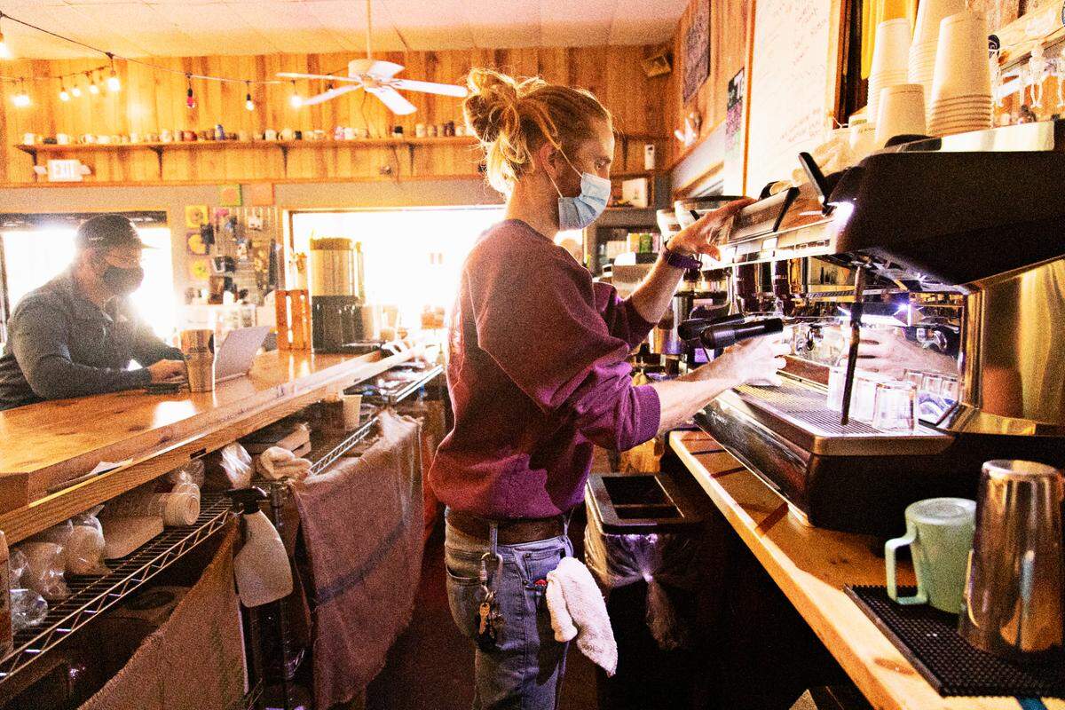 Pine State Coffee manager Lars Robinson, right, makes an oat latte at the Raleigh shop on Tuesday, Nov. 16, 2021.
