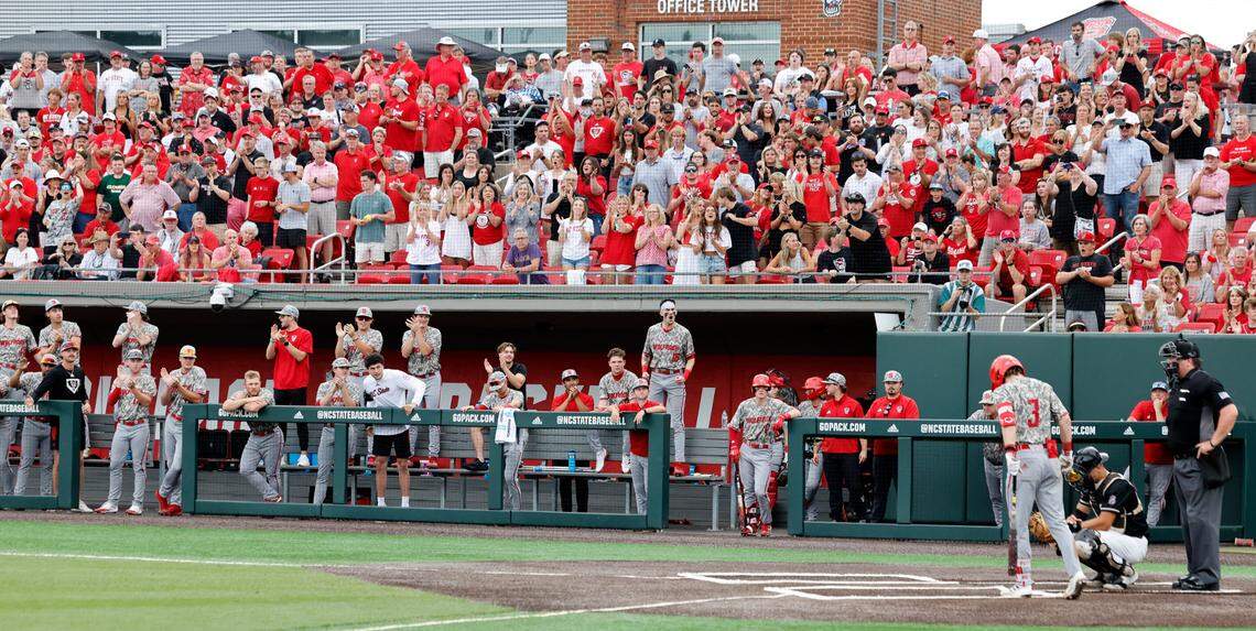 The Wolfpack dugout and fans cheers on Brandon Butterworth (3) before he is walked with bases loaded in the fourth inning during N.C. State’s game against James Madison in the NCAA Raleigh Regional final at Doak Field Sunday, June 2, 2024.