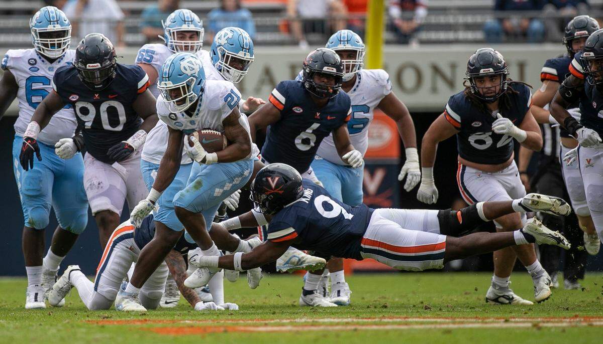 Virginia’s Coen King (9) tries to stop North Carolina’s Elijah Green (21) on a17-yard gain in the first quarter on Saturday, November 5, 2022 at Scott Stadium in Charlottesville, Va.