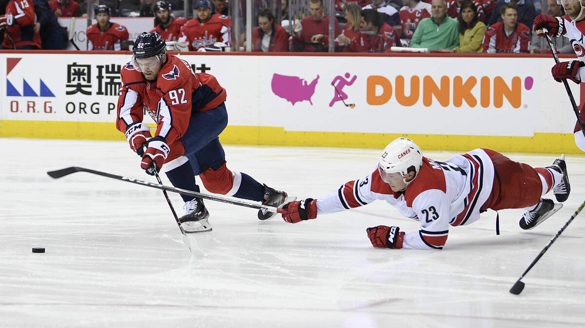 Washington Capitals center Evgeny Kuznetsov (92) chases the puck near Carolina Hurricanes left wing Brock McGinn (23) during the second period of Game 1 of an NHL hockey first-round playoff series Thursday, April 11, 2019, in Washington.