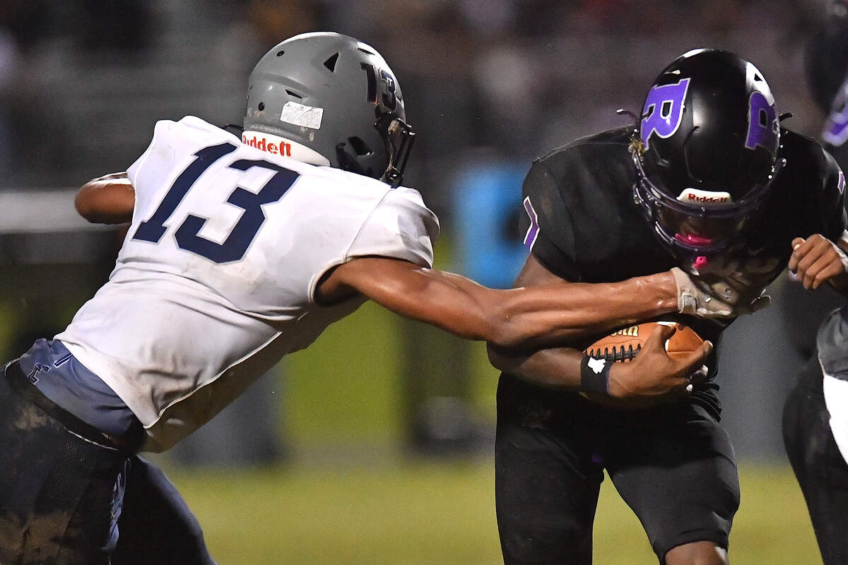 Hillside defensive end Elijah Stevenson (13) grapples Riverside quarterback Tre Belcher (7) during the first half. The Durham Hillside Hornets and the Durham-Riverside Pirates met in a football game in Durham. N.C. on October 4, 2024.