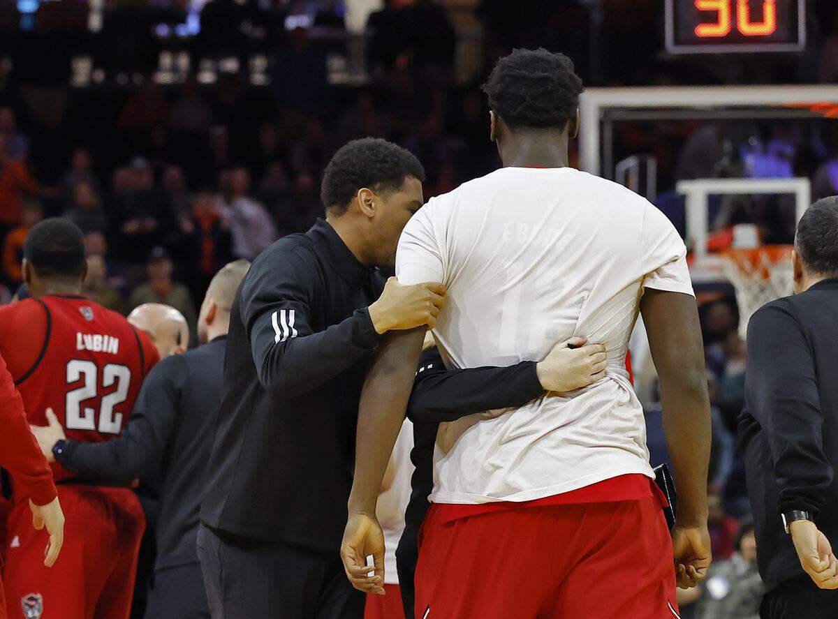 N.C. State personnel separate Scottie Ebube during an on-court skirmish in the second half of the Wolfpack’s 90-61 loss to Virginia on Thursday, Feb. 24, 2026, at John Paul Jones Arena in Charlottesville, Va. 