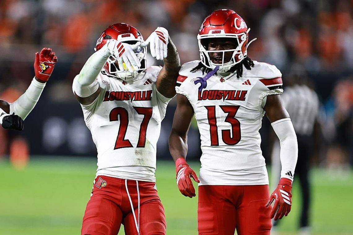 JoJo Evans Jr. (27) of the Louisville Cardinals celebrates his interception with Justin Agu (13) against the Miami Hurricanes during the second half at Hard Rock Stadium on October 17, 2025 in Miami Gardens, Florida.