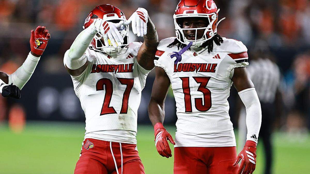 MIAMI GARDENS, FLORIDA - OCTOBER 17: JoJo Evans Jr. #27 of the Louisville Cardinals celebrates his interception with  Justin Agu #13  against the Miami Hurricanes during the second half at Hard Rock Stadium on October 17, 2025 in Miami Gardens, Florida. (Photo by Carmen Mandato/Getty Images)