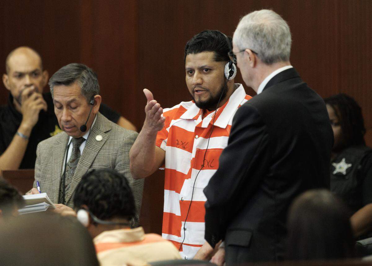 Arturo Marin-Sotelo speaks through an interpreter to Mignon Byrd, sister of Wake County Deputy Ned Byrd, after pleading guilty to accessory after the fact of murder during a hearing at the Wake County Courthouse on Tuesday. His brother, Alder Marin-Sotelo, pleaded guilty to first-degree murder.