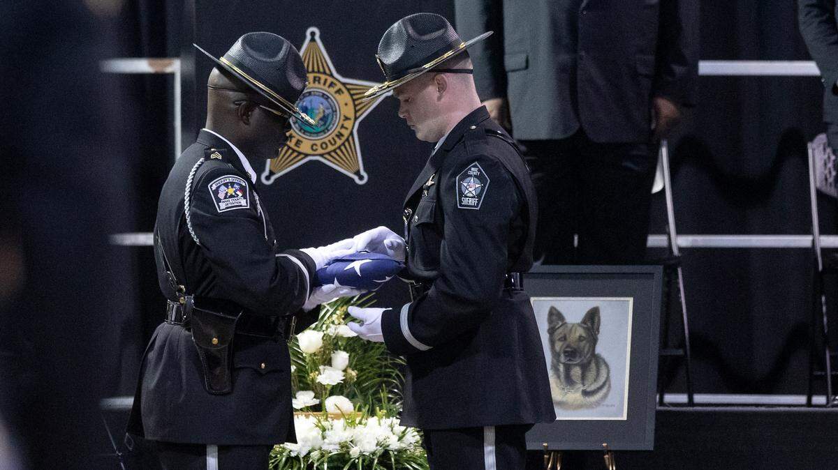 Law enforcement members prepare a flag to present to Master Deputy Maria Fuentes, handler of K9 Santos, at the conclusion of a memorial service for the Wake County sheriff’s dog at the Kerr Scott Building on Wednesday, June 14, 2023, in Raleigh, N.C. K9 Santos, a German shepherd, was accidentally shot and killed by a Knightdale police officer after a traffic stop in May.