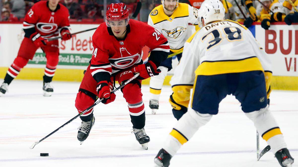 Carolina Hurricanes’ Seth Jarvis (24) is challenged by Nashville Predators’ Jeremy Davies (38) during the second period of an NHL preseason hockey game in Raleigh, N.C., Tuesday, Oct. 5, 2021. (AP Photo/Karl B DeBlaker)