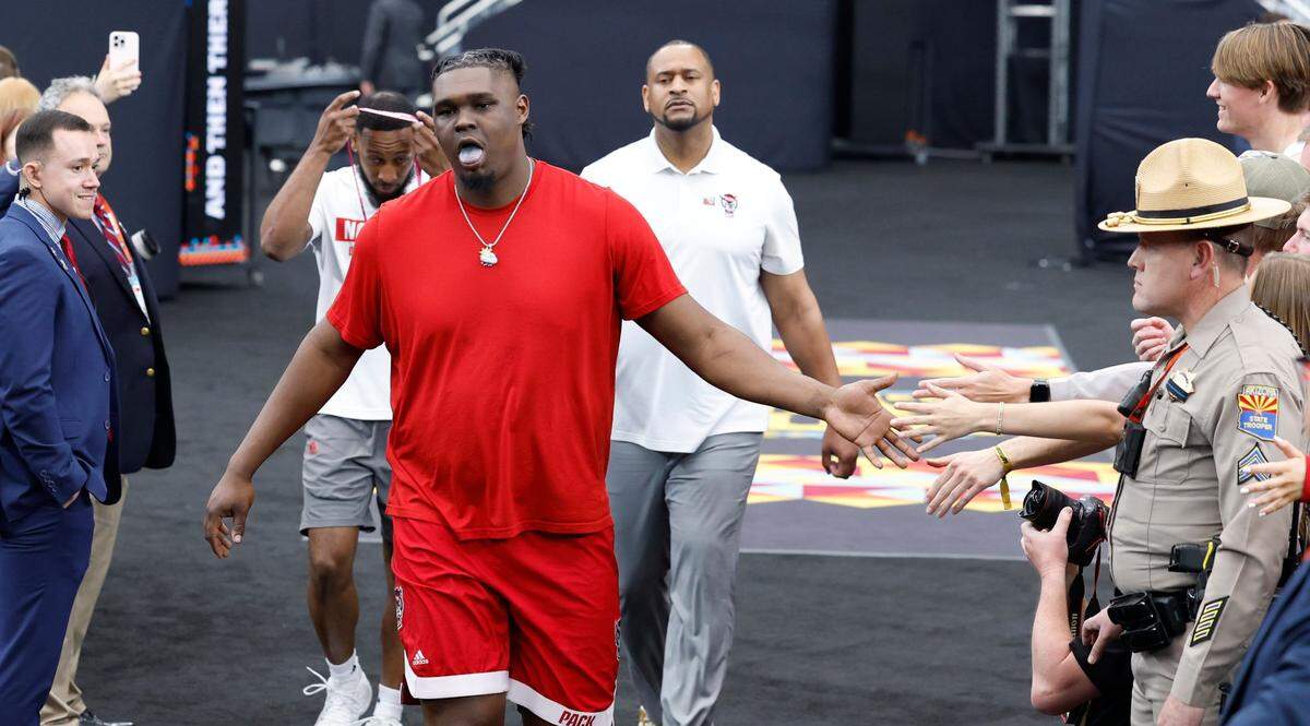 N.C. State’s DJ Burns Jr. greets fans as he walks to the court to warmup before N.C. State’s game against Purdue in the NCAA Tournament national semfinals at State Farm Stadium in Glendale, Ariz., Saturday, April 6, 2024.